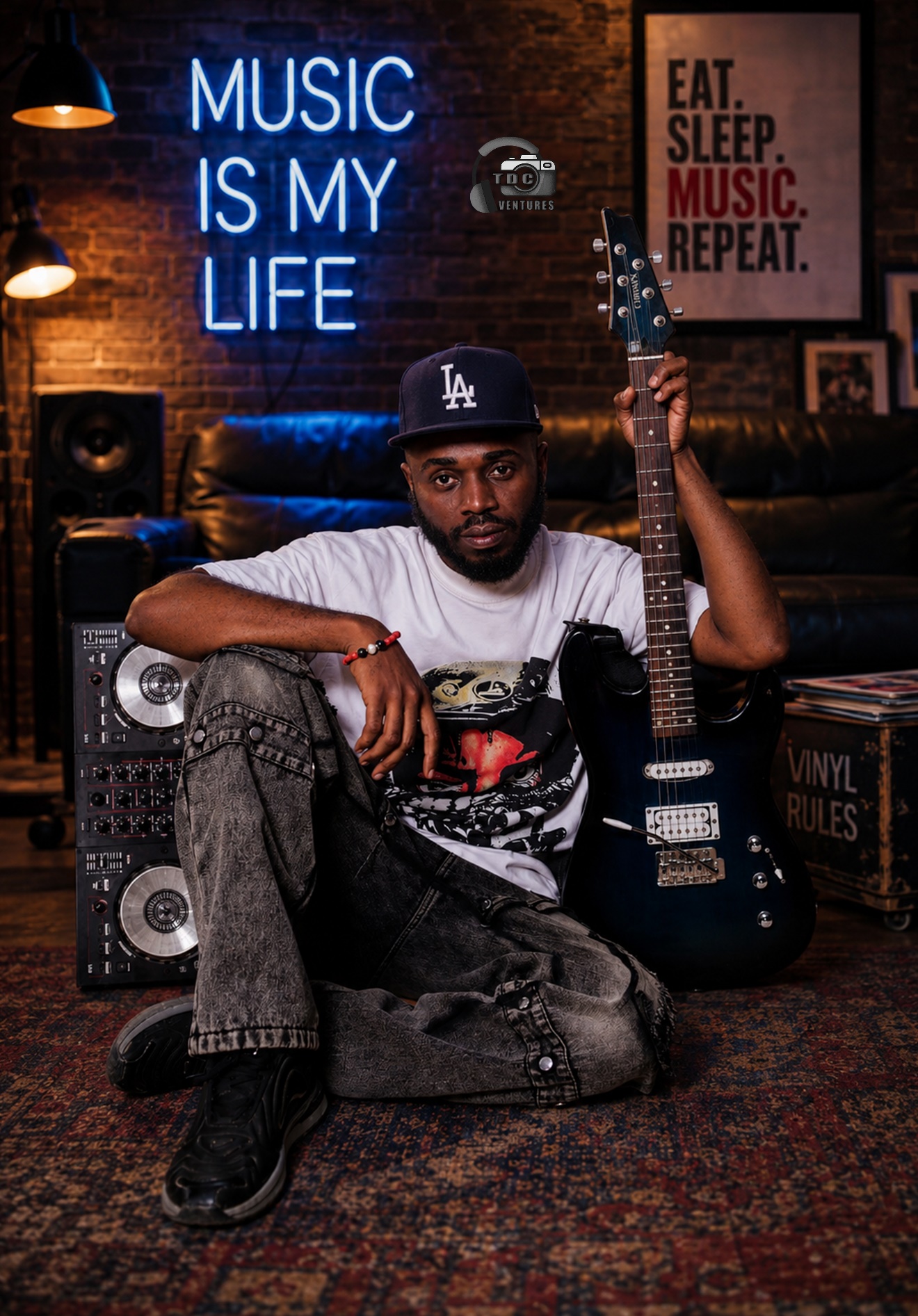 Don 3ple-ig seated in a music studio holding a guitar